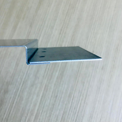 Side view of an overlapping sheet metal assembly with a stepped bend and clinched joining area